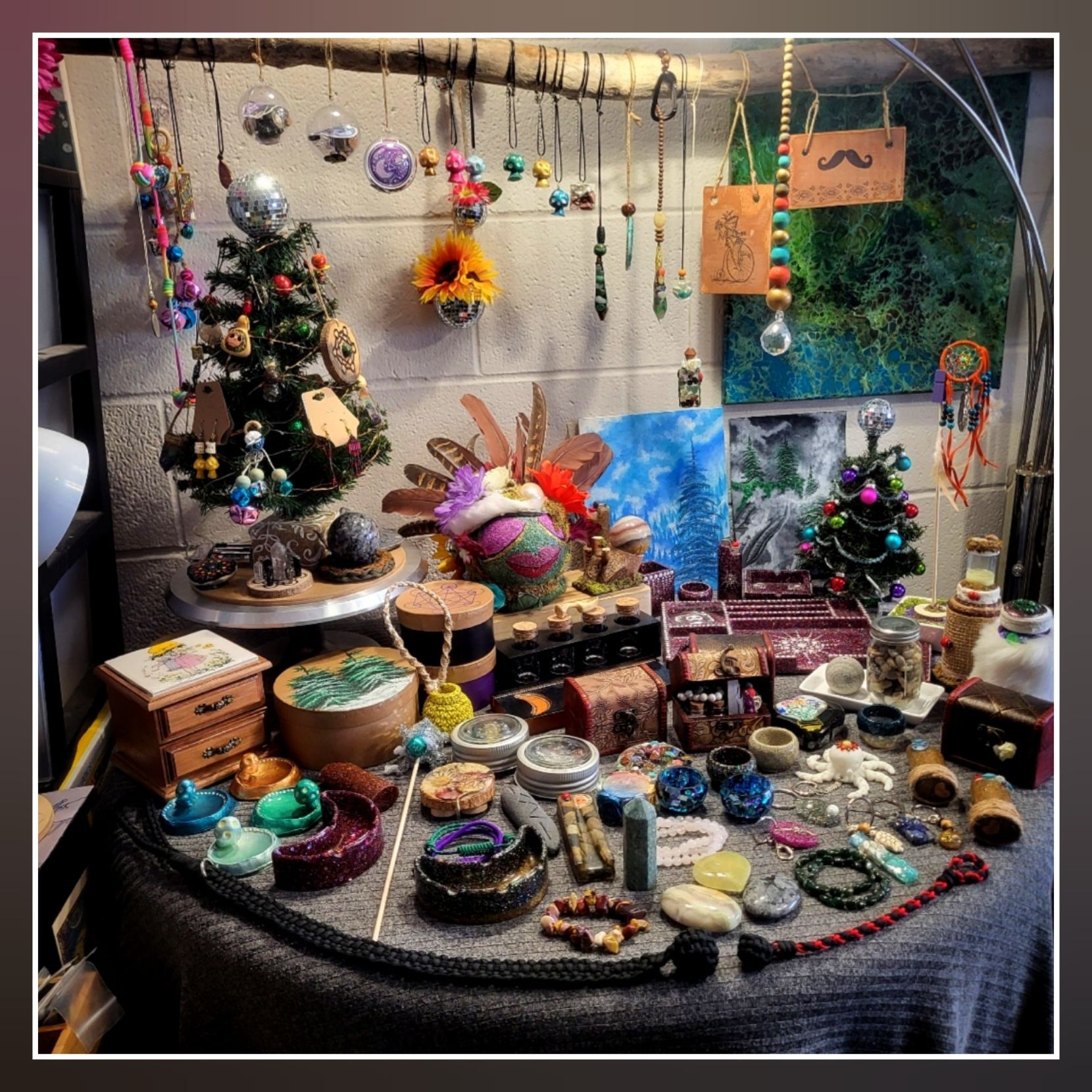 A table displaying various handcrafted items, including jewelry, decorative ornaments, and small art pieces.