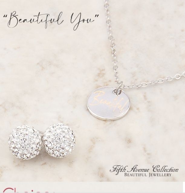 Necklace with 'Beautiful' pendant and sparkling stud earrings on a light background.